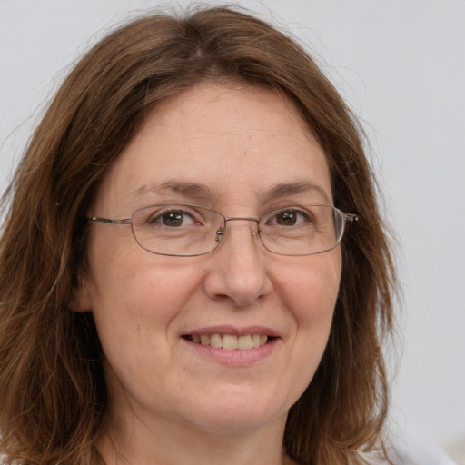 Joyful white adult female with long  brown hair and green eyes