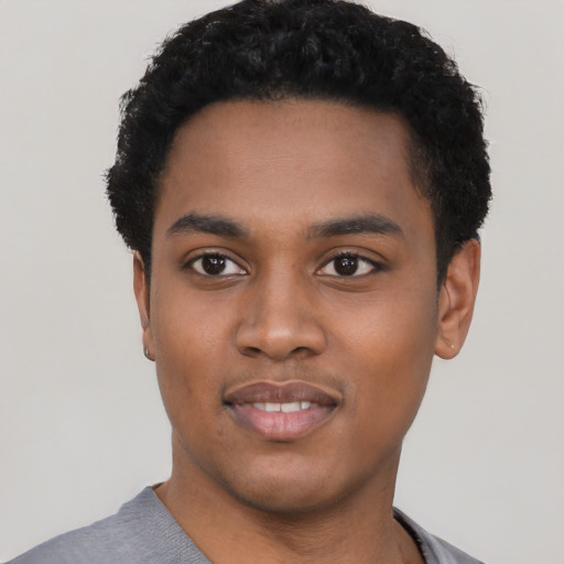 Joyful black young-adult male with short  black hair and brown eyes