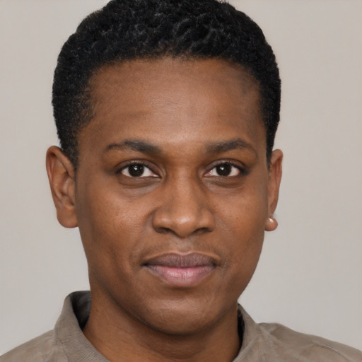 Joyful black young-adult male with short  black hair and brown eyes
