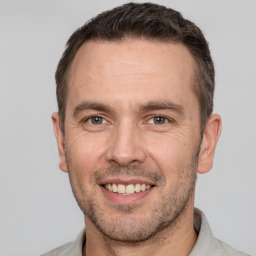 Joyful white adult male with short  brown hair and brown eyes