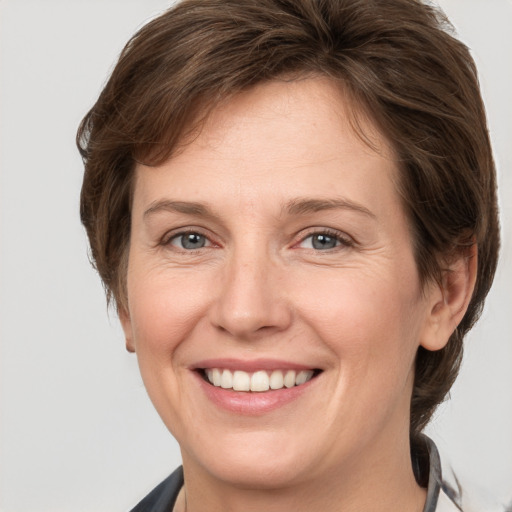 Joyful white adult female with medium  brown hair and grey eyes