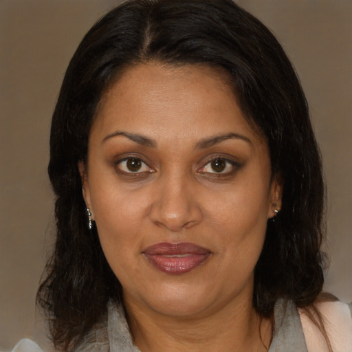 Joyful latino adult female with medium  brown hair and brown eyes