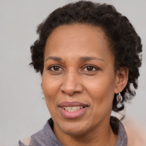 Joyful black adult female with short  brown hair and brown eyes