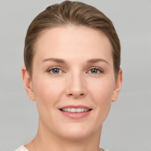 Joyful white young-adult female with short  brown hair and grey eyes