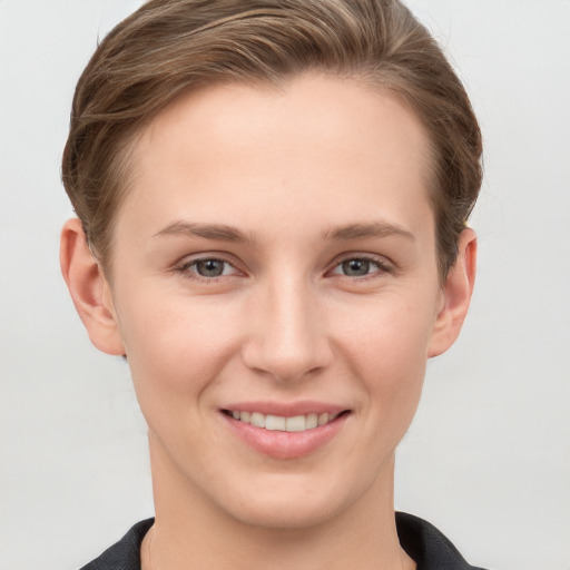 Joyful white young-adult female with short  brown hair and grey eyes