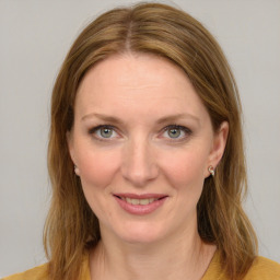 Joyful white young-adult female with long  brown hair and blue eyes