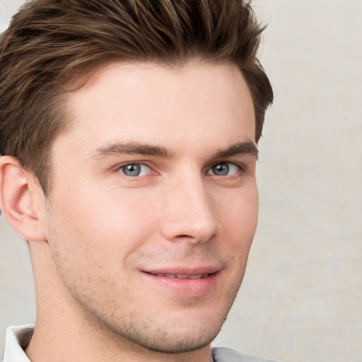 Joyful white young-adult male with short  brown hair and grey eyes