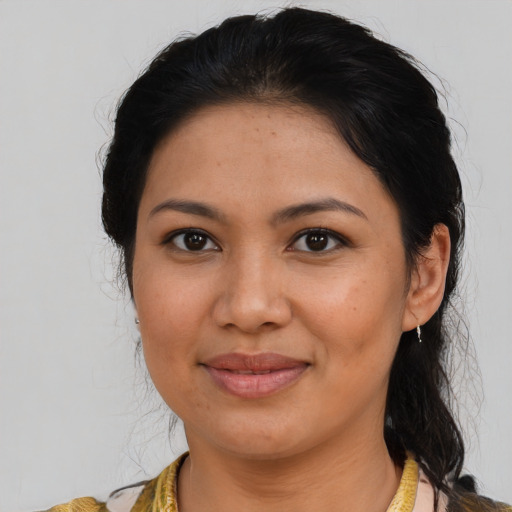 Joyful latino young-adult female with medium  brown hair and brown eyes