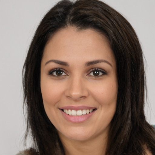 Joyful white young-adult female with long  brown hair and brown eyes