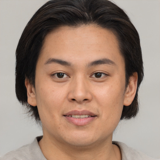 Joyful asian young-adult male with short  brown hair and brown eyes