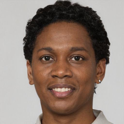 Joyful black adult female with short  black hair and brown eyes