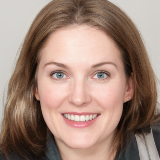 Joyful white young-adult female with medium  brown hair and grey eyes