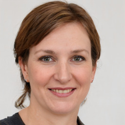 Joyful white young-adult female with medium  brown hair and grey eyes