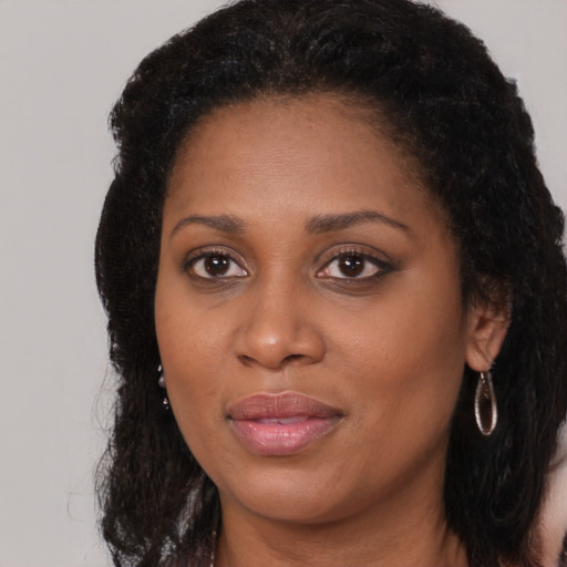 Joyful black young-adult female with long  brown hair and brown eyes