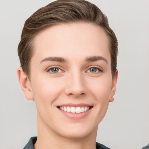 Joyful white young-adult female with short  brown hair and grey eyes