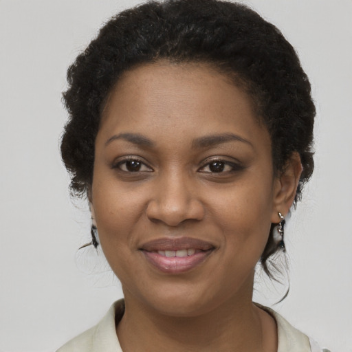 Joyful black young-adult female with short  brown hair and brown eyes