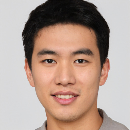 Joyful asian young-adult male with short  black hair and brown eyes