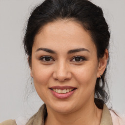 Joyful latino young-adult female with medium  brown hair and brown eyes