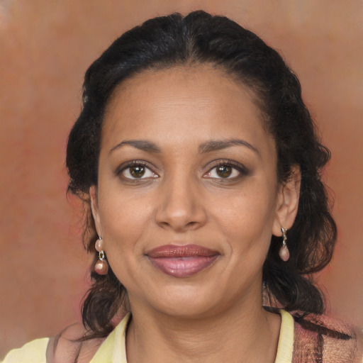Joyful black adult female with medium  brown hair and brown eyes