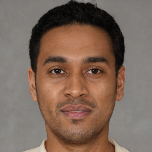 Joyful latino young-adult male with short  black hair and brown eyes