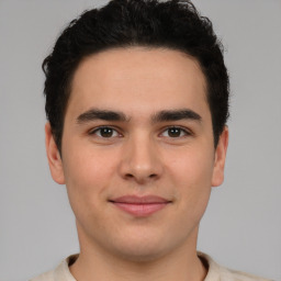 Joyful latino young-adult male with short  brown hair and brown eyes