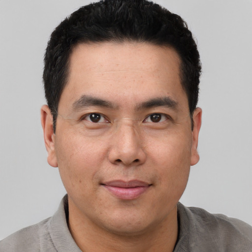 Joyful latino adult male with short  black hair and brown eyes