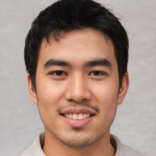 Joyful asian young-adult male with short  black hair and brown eyes