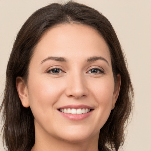 Joyful white young-adult female with long  brown hair and brown eyes