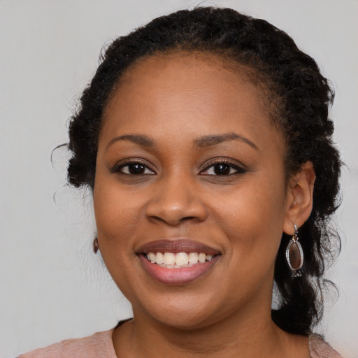 Joyful black young-adult female with medium  black hair and brown eyes