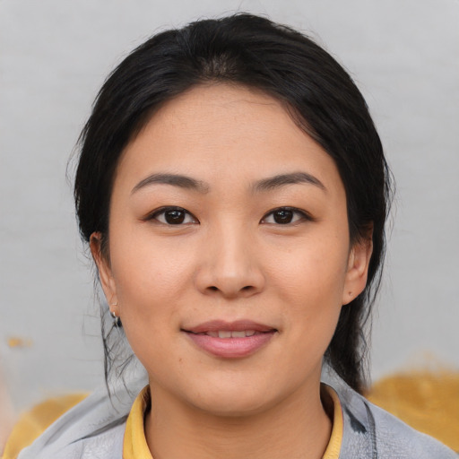 Joyful asian young-adult female with medium  black hair and brown eyes