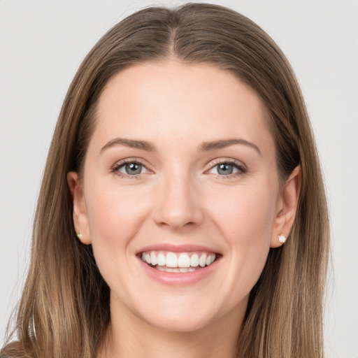 Joyful white young-adult female with long  brown hair and grey eyes