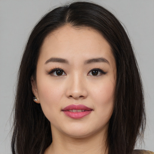 Joyful asian young-adult female with long  brown hair and brown eyes