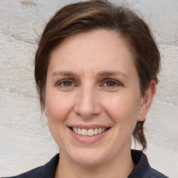 Joyful white adult female with medium  brown hair and grey eyes