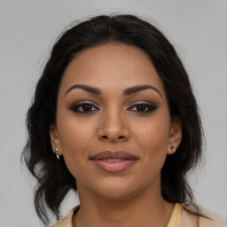 Joyful latino young-adult female with medium  brown hair and brown eyes