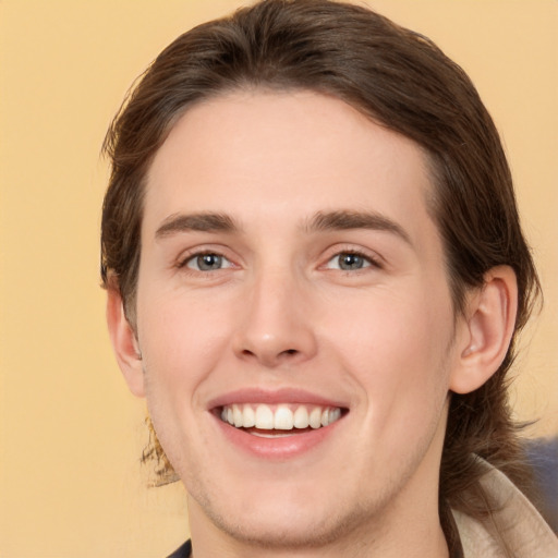 Joyful white young-adult male with medium  brown hair and brown eyes