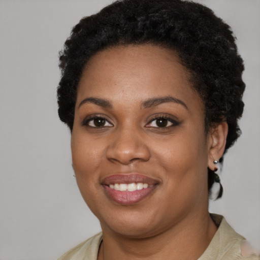 Joyful black young-adult female with short  black hair and brown eyes