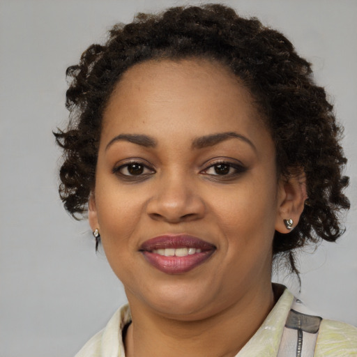 Joyful black young-adult female with medium  brown hair and brown eyes