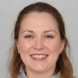 Joyful white adult female with medium  brown hair and grey eyes