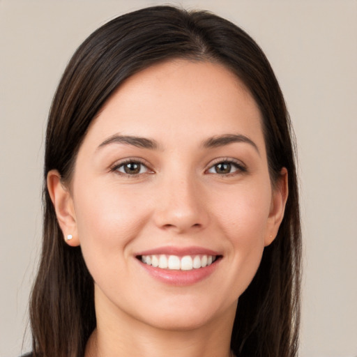 Joyful white young-adult female with long  brown hair and brown eyes