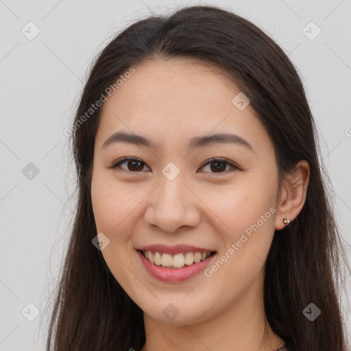 Joyful white young-adult female with long  brown hair and brown eyes