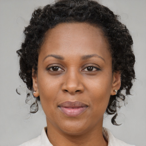 Joyful black adult female with medium  brown hair and brown eyes