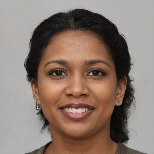 Joyful black young-adult female with medium  black hair and brown eyes