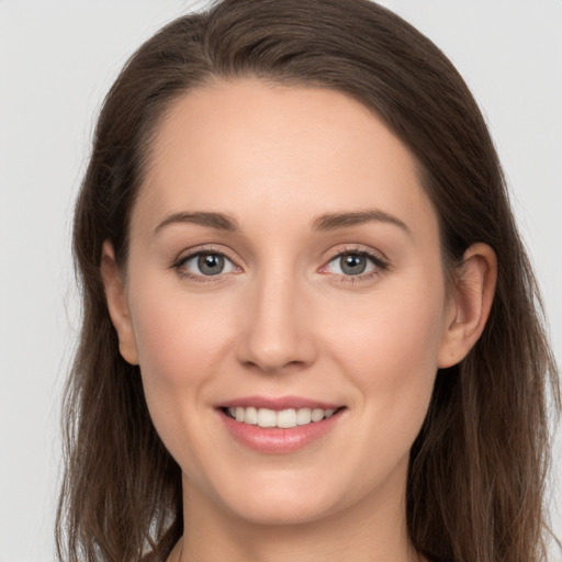 Joyful white young-adult female with long  brown hair and grey eyes