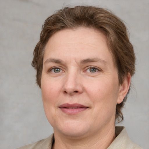 Joyful white adult female with short  brown hair and blue eyes