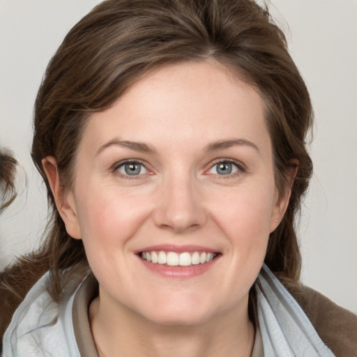 Joyful white young-adult female with medium  brown hair and blue eyes