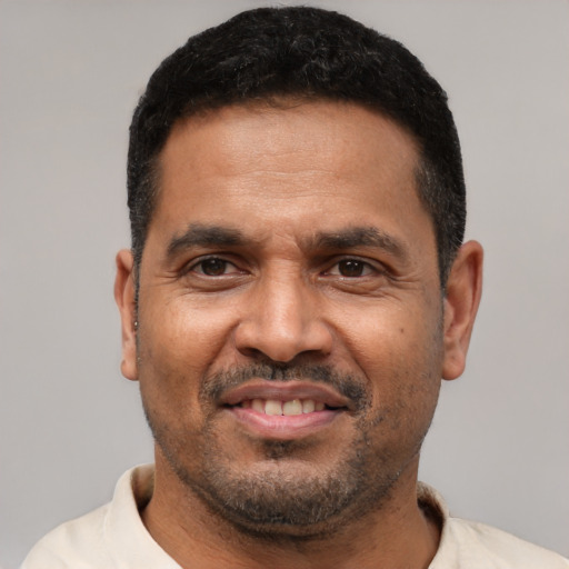 Joyful latino adult male with short  black hair and brown eyes