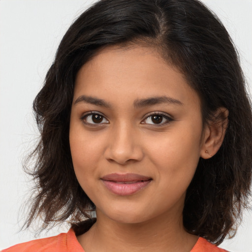 Joyful latino young-adult female with medium  brown hair and brown eyes