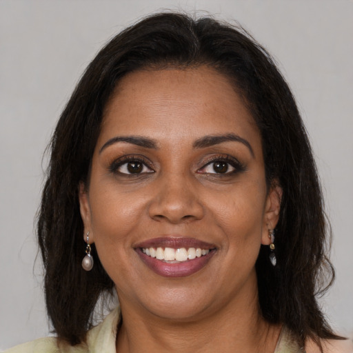 Joyful black young-adult female with medium  brown hair and brown eyes