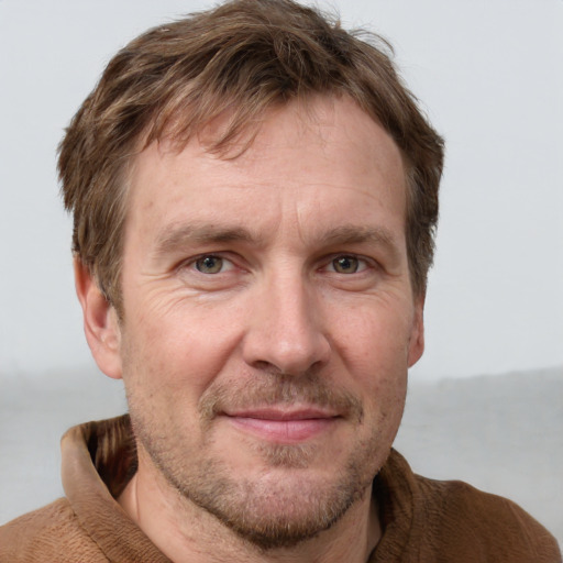 Joyful white adult male with short  brown hair and grey eyes