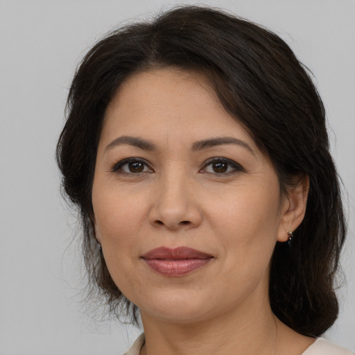 Joyful latino adult female with medium  brown hair and brown eyes